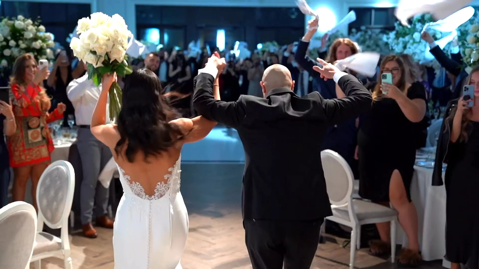 Yasmine & Michael from behind,cheering as they run into their reception hall during their grand entrance.